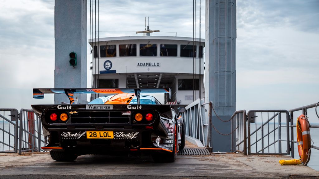 A McLaren F1 supercar boarding a ferry on Lake Garda in Italy. Iconic road trip scene.