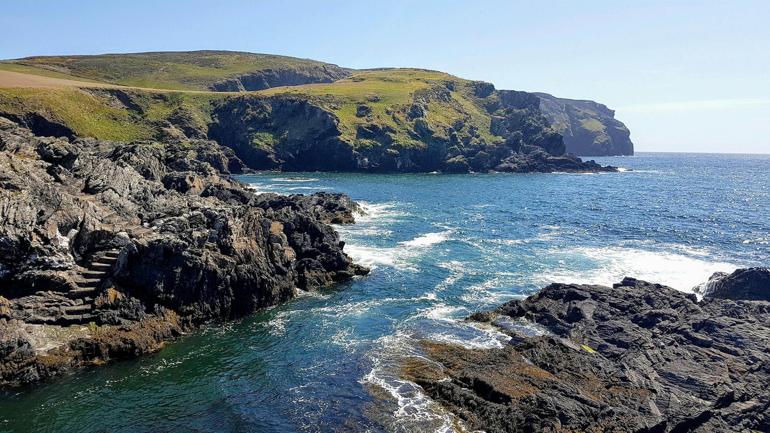 Captivating view of the rugged coastline and blue sea at the Isle of Man.