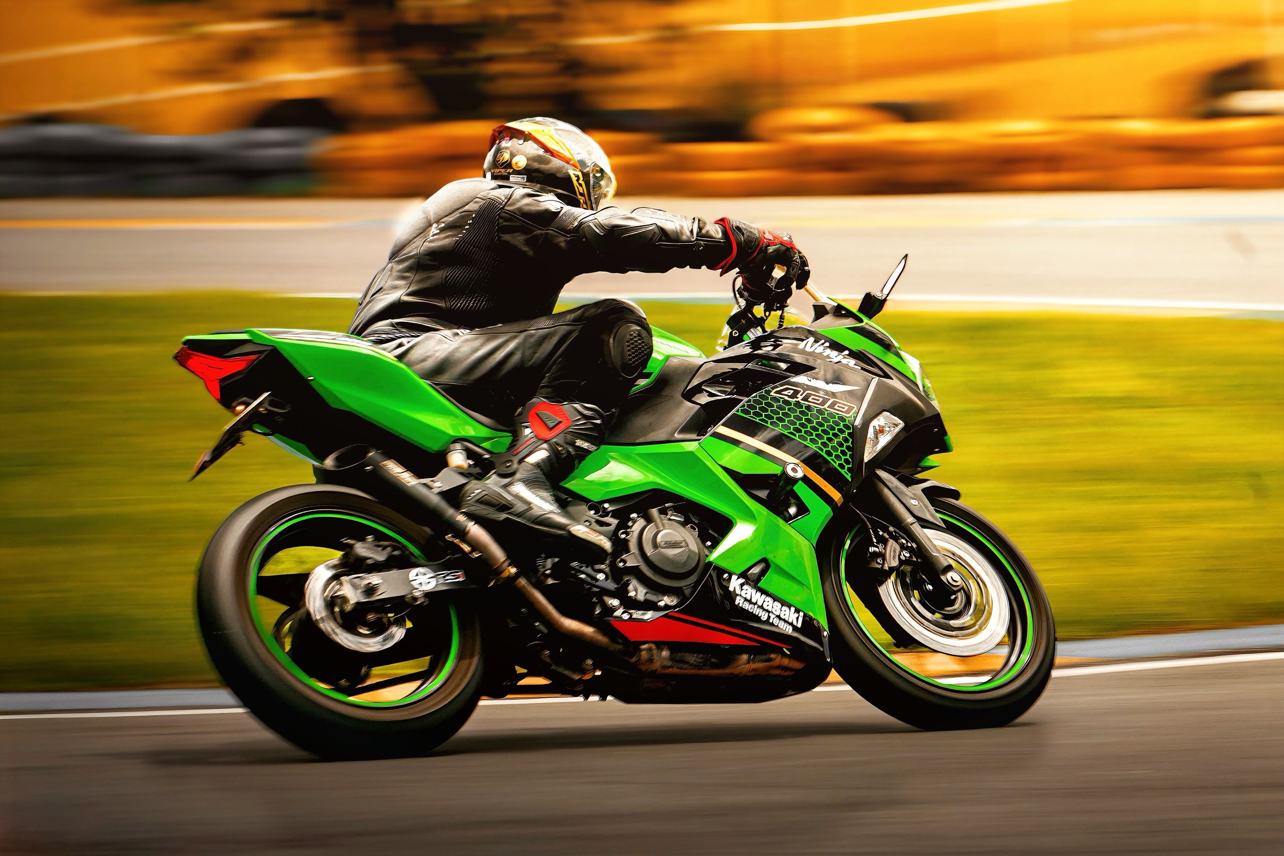 Rider on a vibrant green motorcycle racing on a track, creating a dynamic and thrilling scene.