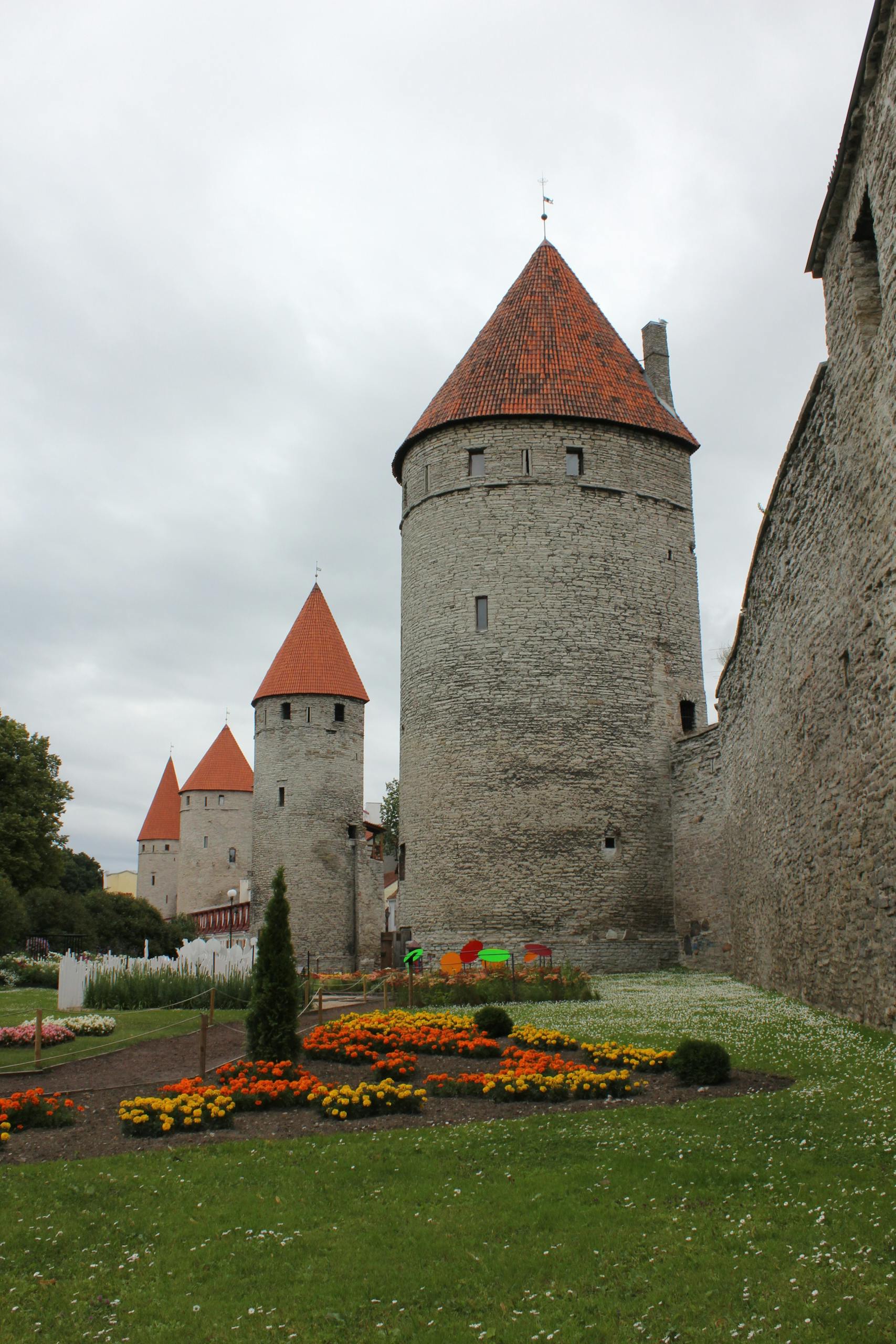 Scenic view of Tallinn's medieval towers with vibrant gardens.