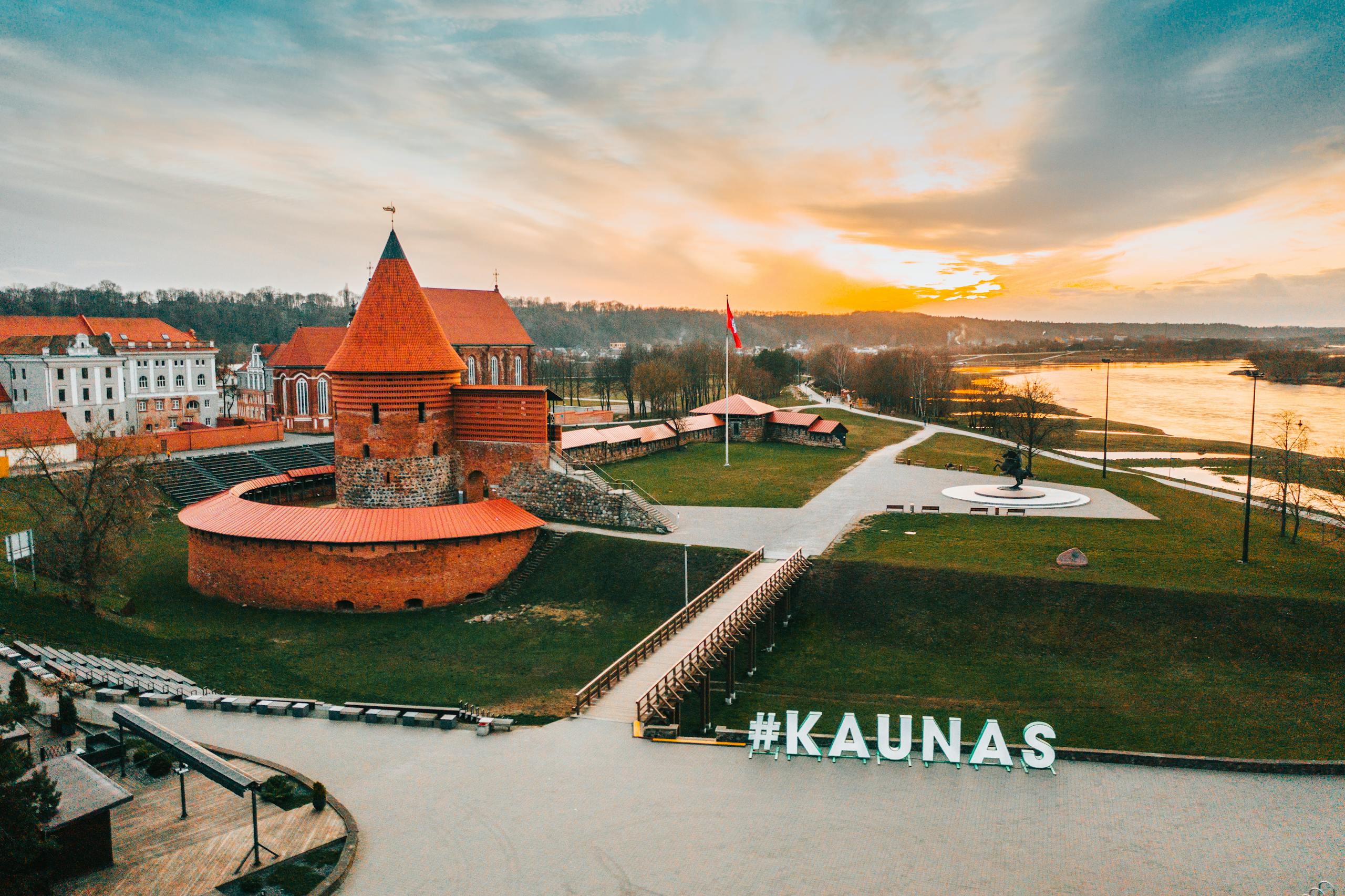 Stunning aerial view of historic Kaunas Castle in Lithuania during golden hour, showcasing vibrant skyline.