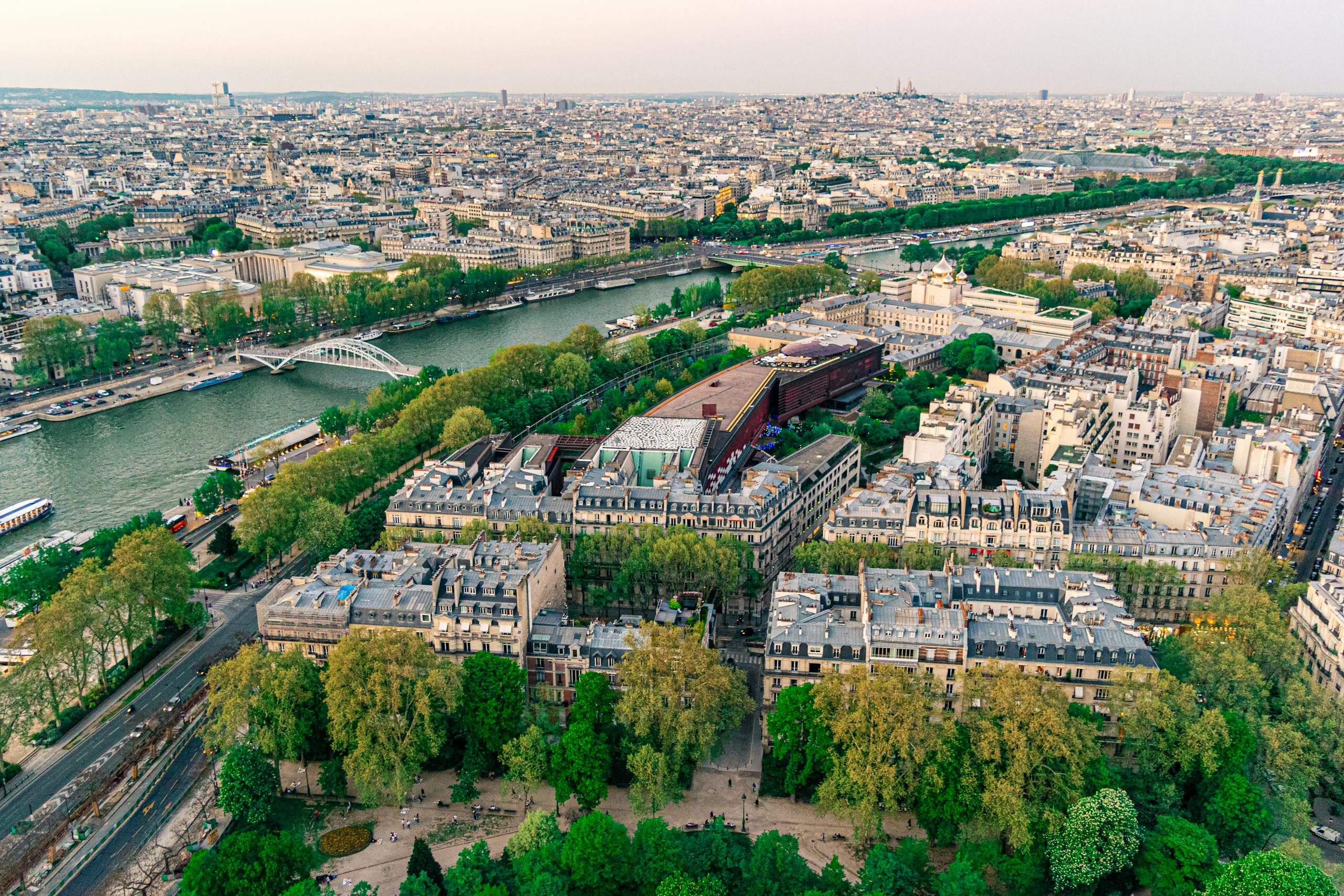 Stunning aerial view of Paris showcasing the Seine River and iconic architecture under a clear sky.