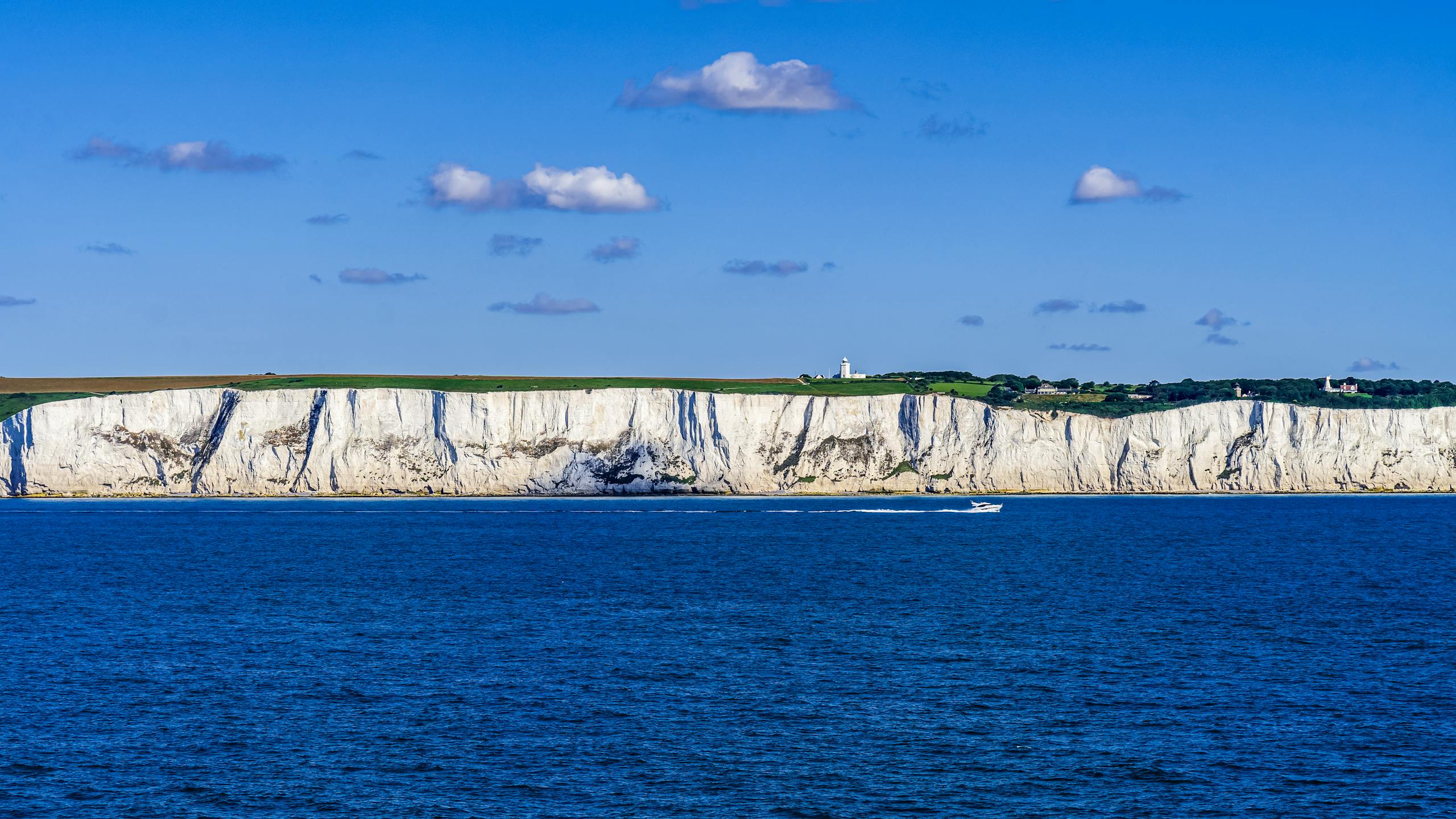 Stunning view of the iconic White Cliffs of Dover with a vibrant blue sea and clear sky.