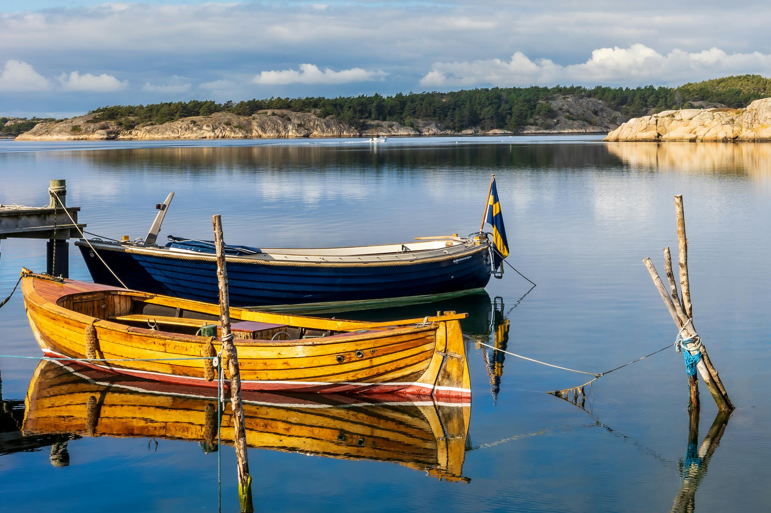 Vibrant wooden boats moored in the tranquil waters of Havstenssund, Sweden, reflecting a serene coastal scene.